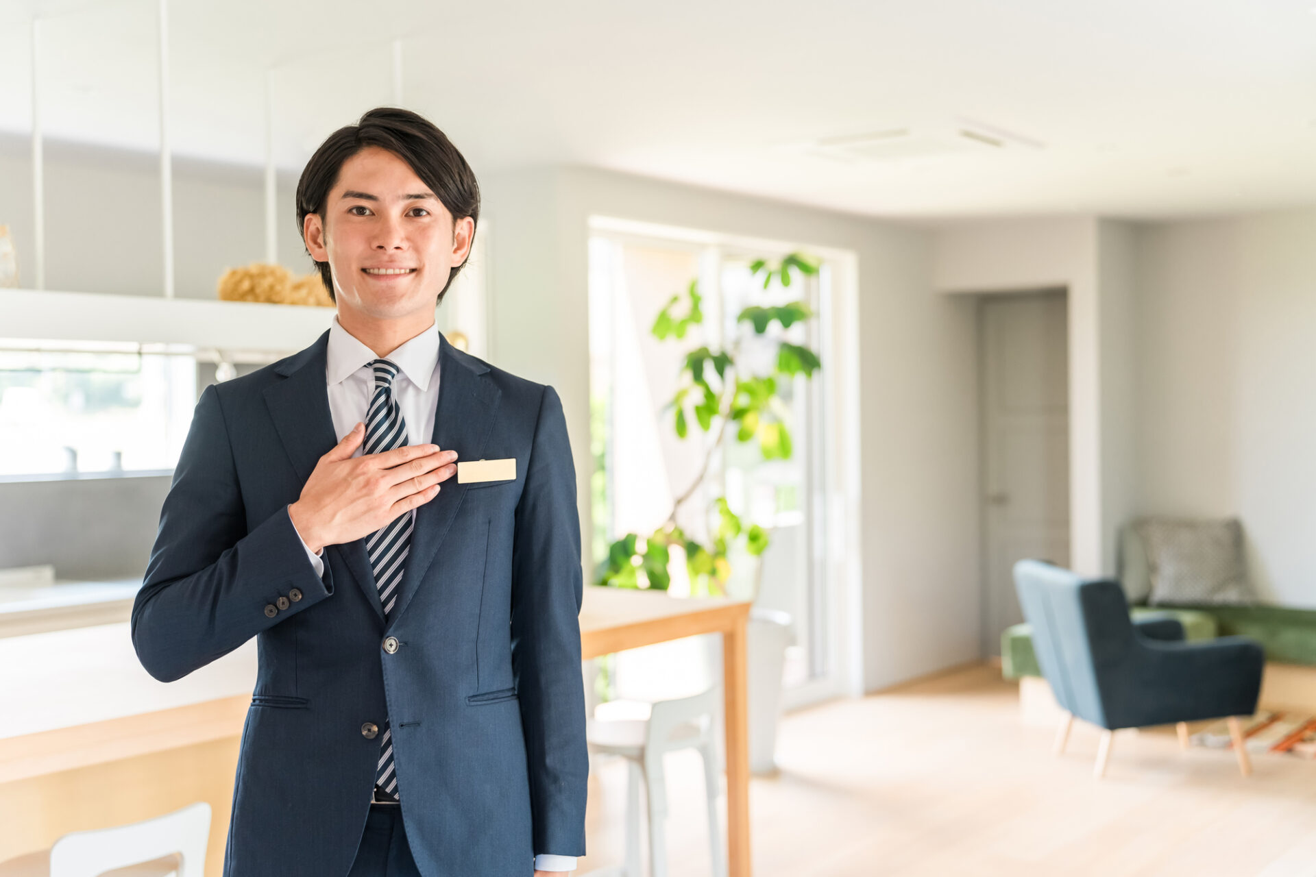 住宅のリビングで笑顔の営業担当者が対応する様子。信頼できる住宅会社のイメージ