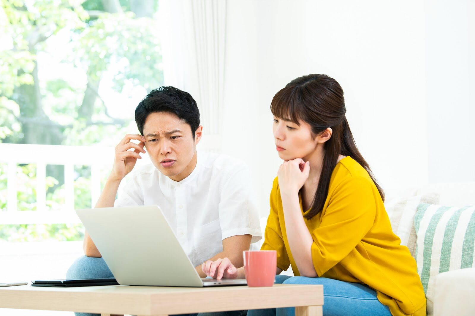 住宅ローン返済や資金計画に悩む夫婦のイメージ