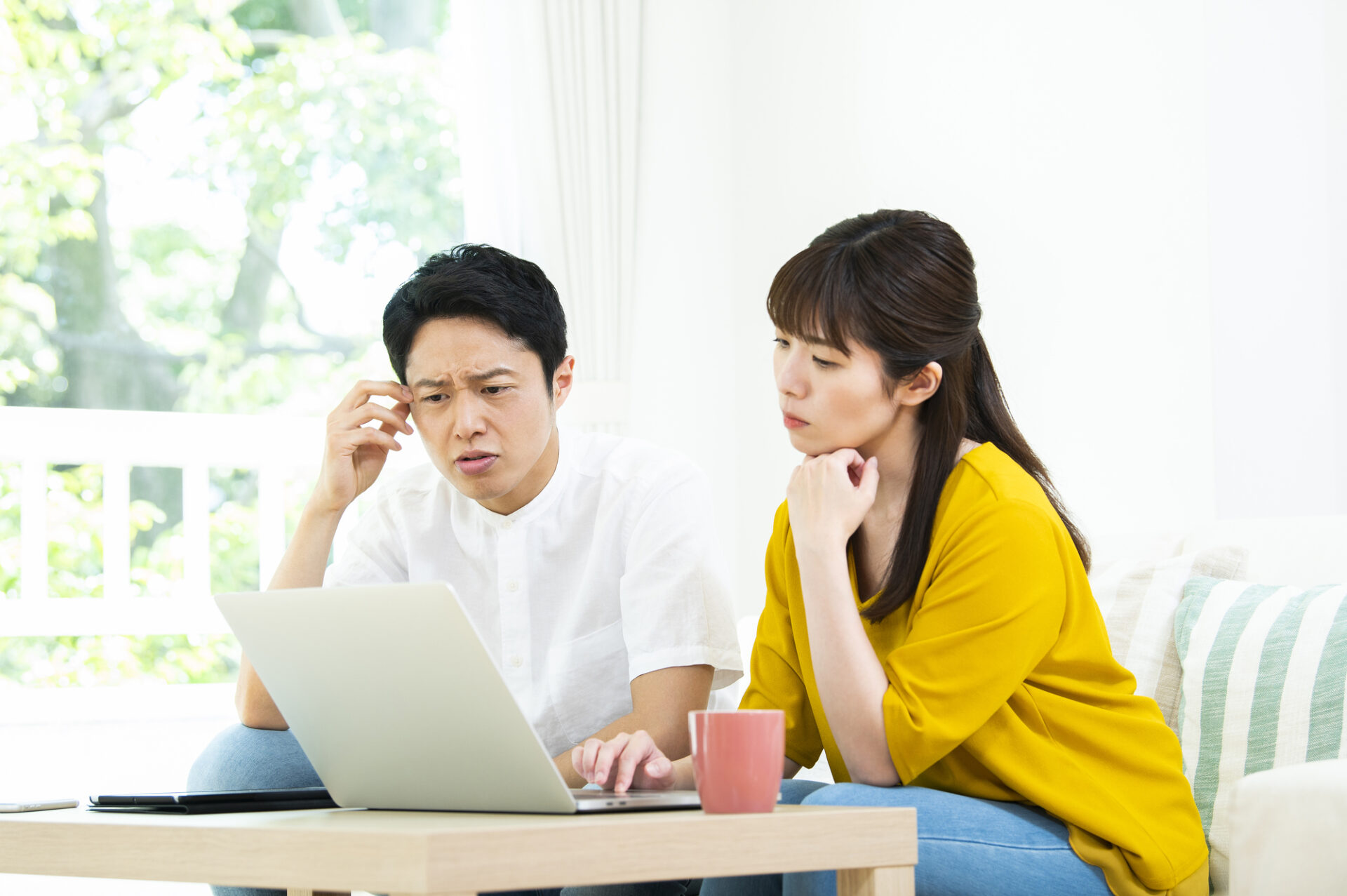 住宅ローン返済や資金計画に悩む夫婦のイメージ
