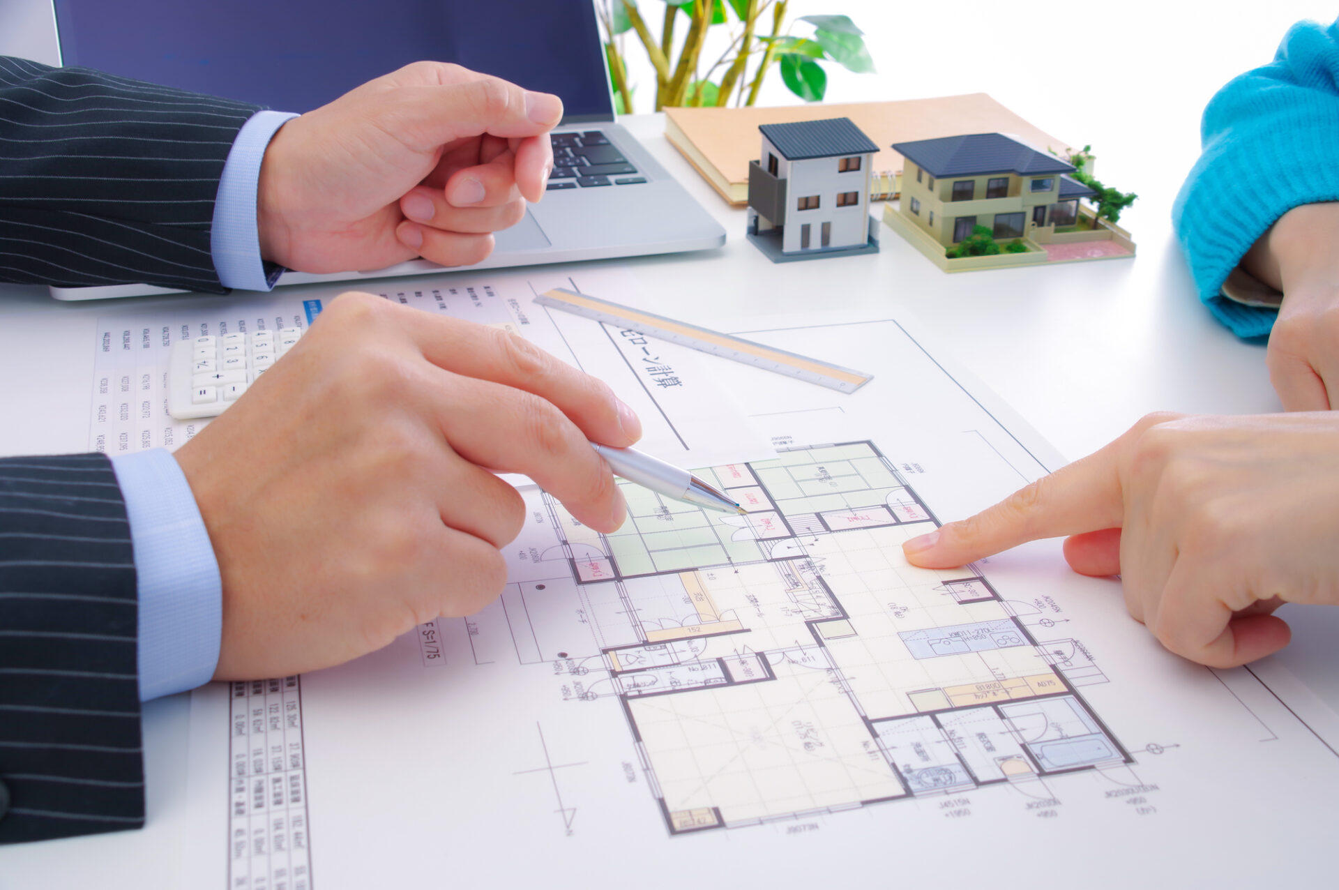 注文住宅の打ち合わせ風景。間取り図を見ながら住宅設備を検討する様子。2025年の家づくりで古く見えない設備選びを考えるシーン。