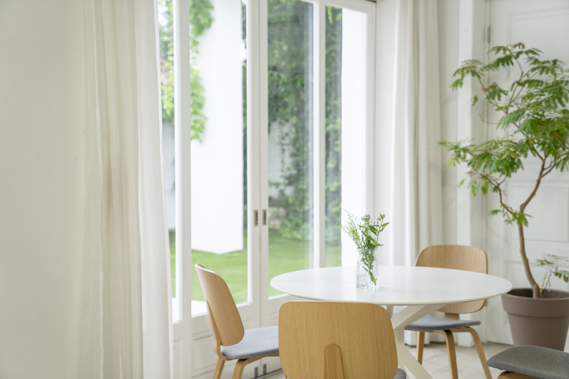 白を基調とした明るいダイニング。自然光が差し込むナチュラルモダンな空間で、古く見えない注文住宅デザインの一例。