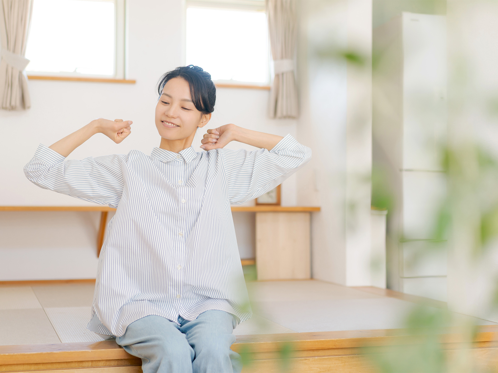 リビングで伸びをする女性_小上がり畳